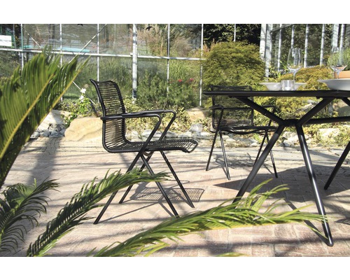 Scène de jardin avec table et chaises en métal sur une terrasse
