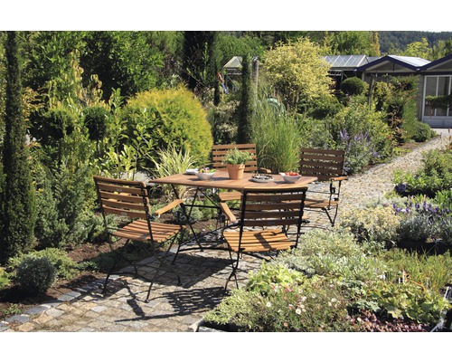 Scène de jardin avec table à manger et chaises entourées de plantes