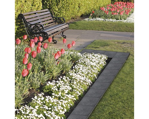 Scène de jardin avec pelouse, fleurs et bordure de parterre en pierre