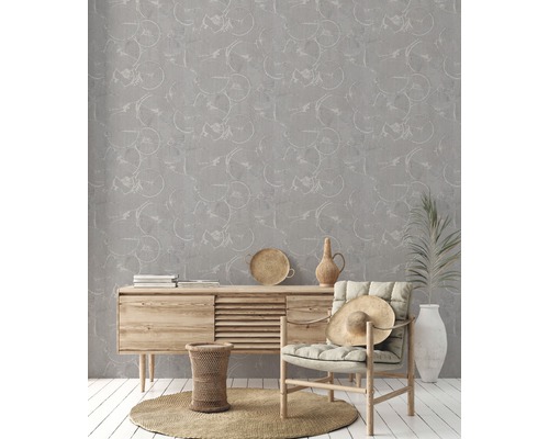 Wohnzimmer mit grauer Mustertapete, Kommode und Sessel