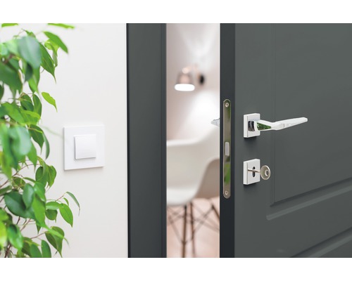 Geöffnete graue Innentür mit silberfarbener Türklinke und Schlüssel