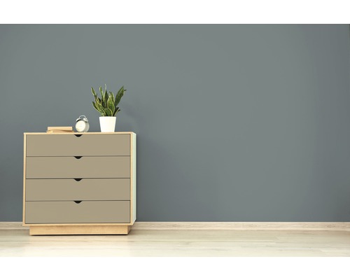 Kommode mit vier Schubladen, Tischuhr und Zimmerpflanze