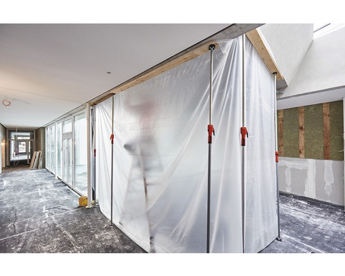 Chantier avec murs de protection contre la poussière et supports télescopiques dans une pièce