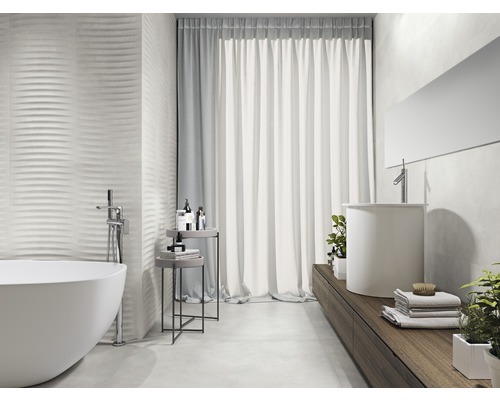 Badezimmer mit Badewanne, Waschbecken und strukturierten Wandfliesen