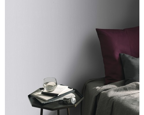 Schlafzimmer mit Wandtapete, Nachttisch und Bett