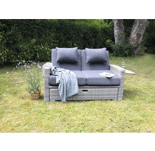 Scène de jardin avec canapé lounge deux places gris comprenant des coussins et une couverture à l''extérieur