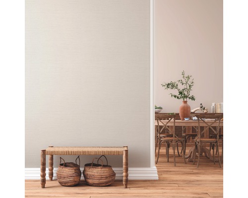 Wohnraum mit Textiltapete, Holzboden, Sitzbank und Essbereich im Hintergrund.