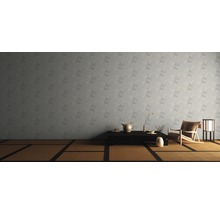 Ein Wohnzimmer mit einer gemusterten Tapete, einem Tatamiboden, einem niedrigen Tisch und einem Sessel.