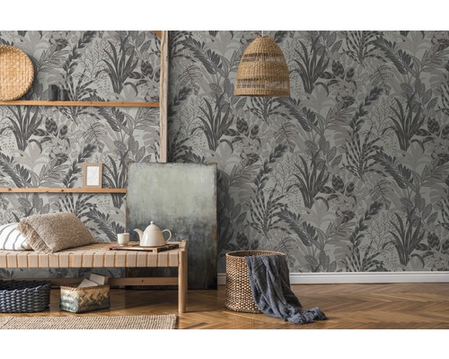 Espace de vie avec papier peint jungle, lit en bois et décorations pour une atmosphère naturelle.