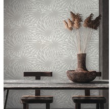 Une pièce avec un papier peint à motifs, une table en bois et un panier de plantes ornementales.