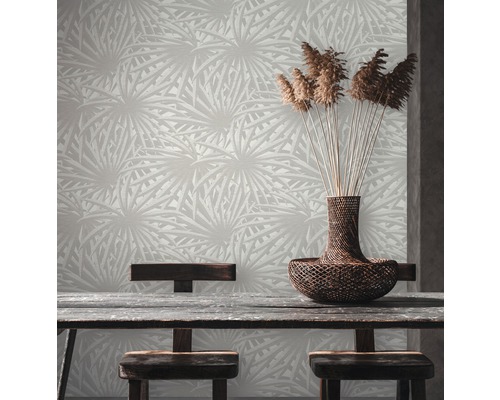 Ein Raum mit einer gemusterten Tapete, einem Holztisch und einem Korb mit Zierpflanzen.