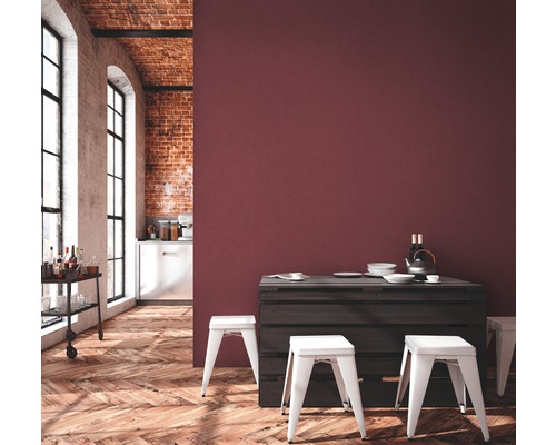 Pièce lumineuse avec parquet, mur en briques, chariot de bar, table à manger en palettes et tabourets blancs devant un mur