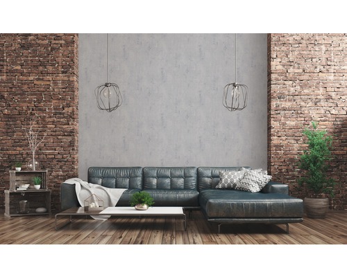 Wohnzimmer mit Ledersofa, Couchtisch, Regalen, Zimmerpflanzen und Ziegelwand