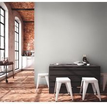 Pièce lumineuse avec table, tabourets, plancher en bois et mur en briques