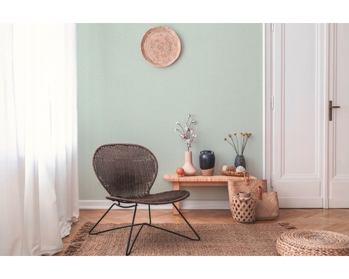 Wohnzimmer mit Rattanmöbeln und heller Wandgestaltung für eine freundliche Atmosphäre.