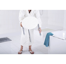 Femme en peignoir tenant un tabouret de douche