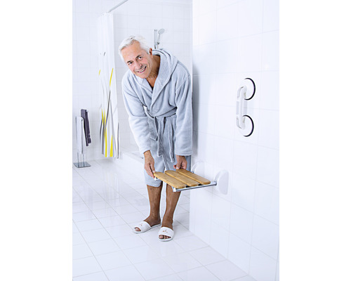 Badezimmer mit Mann im Bademantel, Duschsitz und Haltegriff