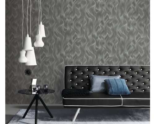 Salon avec papier peint gris, canapé noir et lampes blanches