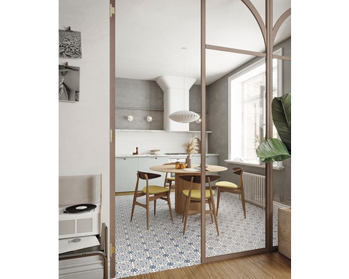 Esszimmer mit rundem Holztisch, Stühlen und Fliesenboden mit blauem Muster