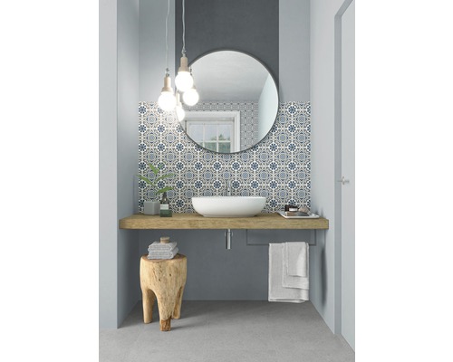 Modernes Badezimmer mit Waschbecken, Spiegel und gemusterten Fliesen.