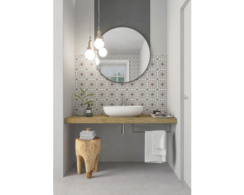 Badezimmer mit Aufsatzwaschbecken, Spiegel, Holzhocker und gemusterten Fliesen