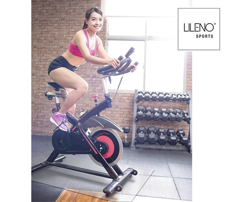 Femme s''entraîne sur un vélo de biking d''intérieur de LILENO SPORTS dans une salle de sport.