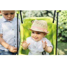 Baby in einer Schaukel mit Hut, daneben ein Kind