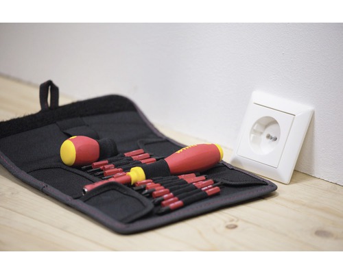 Schraubendreher-Set in einer Werkzeugtasche neben einer Steckdose