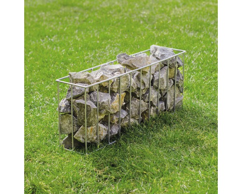 Gabione aus Metallgitter gefüllt mit Steinen auf einer Rasenfläche
