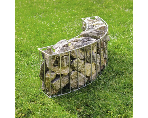 Gabion en forme incurvée rempli de pierres sur une pelouse