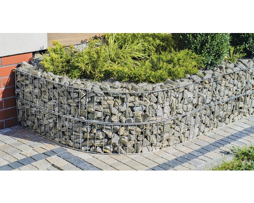 Mur de gabions avec pierres et plantes dans le jardin.
