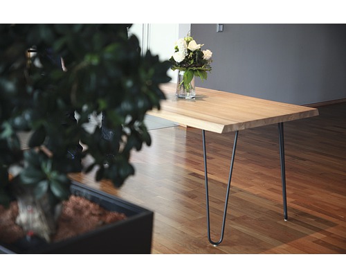 Heller Holztisch mit Metallbeinen und Blumenvase auf einem Holzboden.