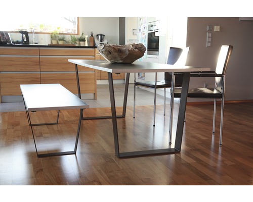 Salle à manger avec table, banc et chaises dans une pièce lumineuse.