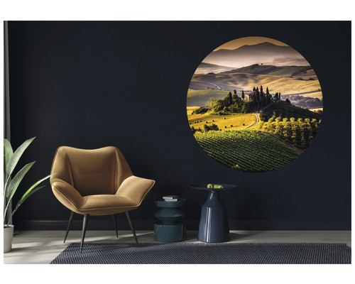 Salon avec fauteuil, tables d''appoint et décoration murale ronde avec motif de paysage