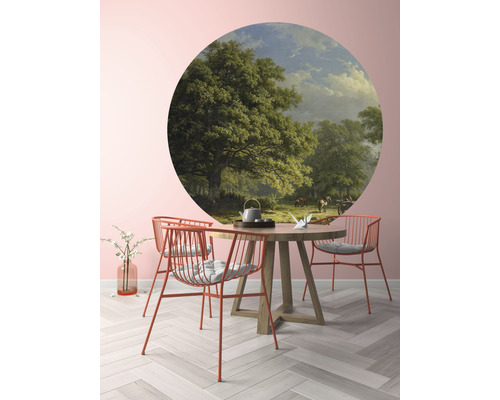 Wandbild mit Landschaftsmotiv über einem runden Holztisch mit Stühlen