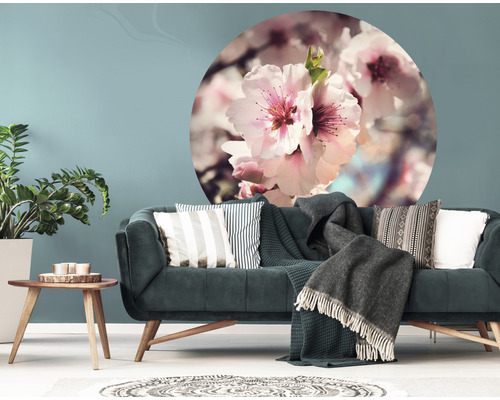 Wohnzimmer mit Sofa, Kissen, Decken, Tisch und Wandtattoo mit Blumenmotiv