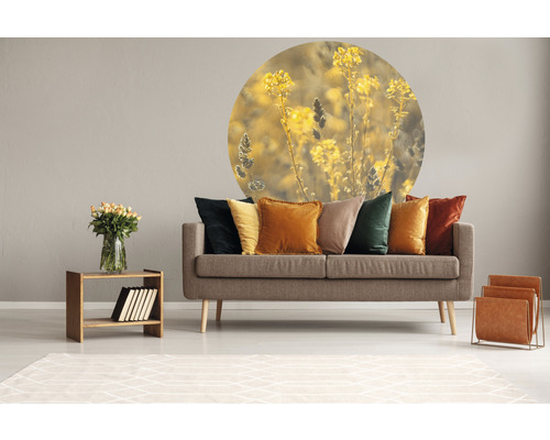 Wohnzimmer mit Sofa, Kissen, Tisch, Blumenstrauß, Zeitschriftenständer und Wandtattoo