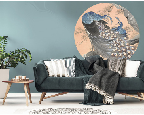 Wohnzimmer mit einem Sofa und einem Wandtattoo mit Pfauenmotiv