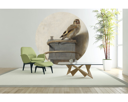 Salon avec fauteuil, repose-pieds, table basse, plante d''intérieur et fresque murale avec motif d''oiseau