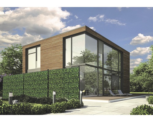 Modernes Haus mit Glasfassade und Sichtschutz aus künstlichen Blättern im Garten.