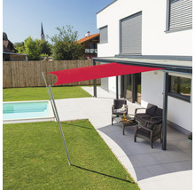 Terrasse avec voile d''ombrage rouge, coin salon et piscine dans le jardin