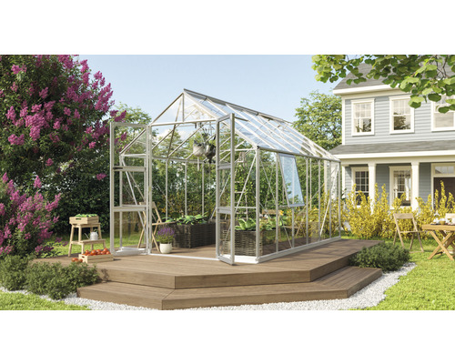 Gewächshaus mit Pflanzen und Gartenzubehör auf einer Terrasse