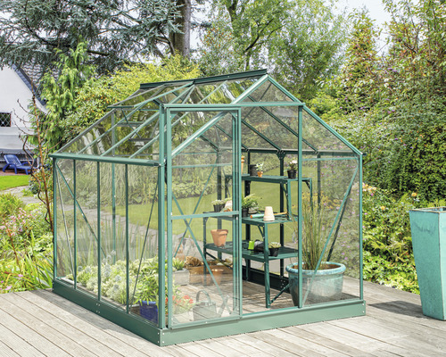 Serre avec étagères dans le jardin