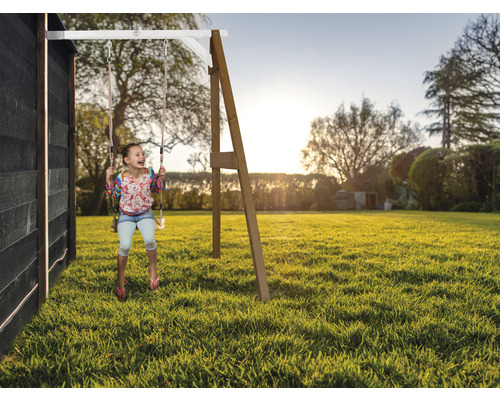 Mädchen schwingt auf einer Gartenschaukel im Garten