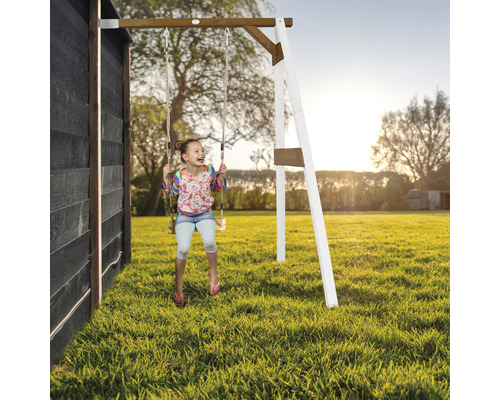 Mädchen schwingt auf einer Holzschaukel im Garten