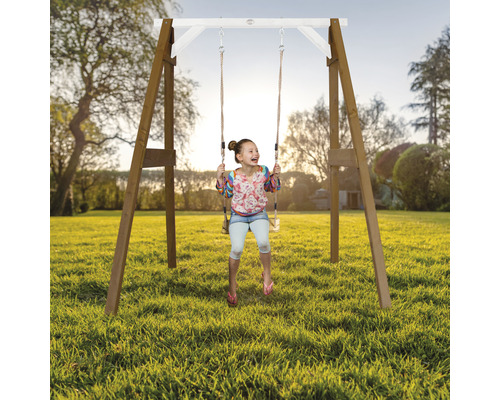 Mädchen schwingt auf einer Holzschaukel im Garten.