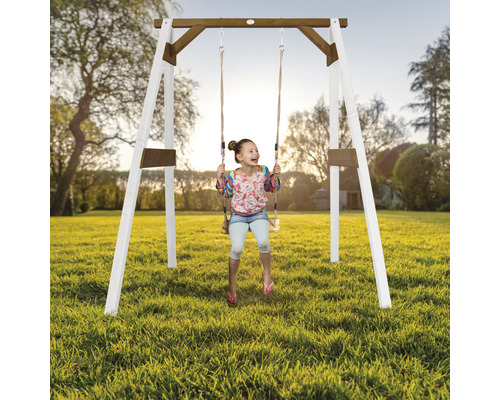 Kind schwingt auf einer Holzschaukel im Garten