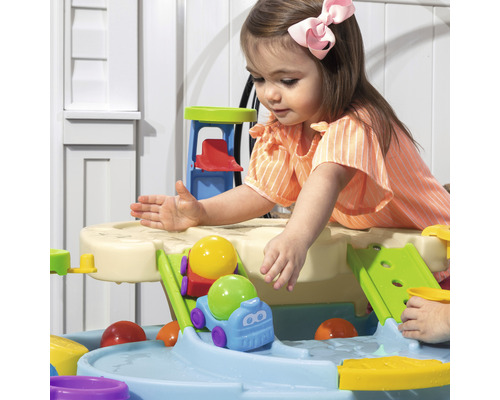 Enfant joue avec une glissière d''eau dans le jardin