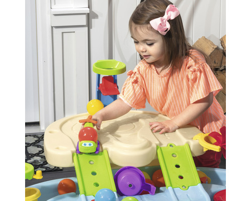 Une petite fille joue avec une table de jeu d''eau pour l''extérieur.