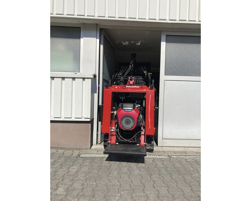 Appareil motorisé à chenilles devant l''entrée de l''entrepôt